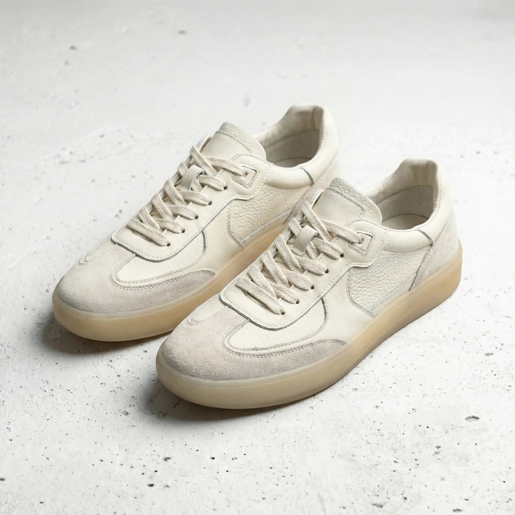 Pair of beige leather trainers with suede trim and translucent gum soles shown side by side.