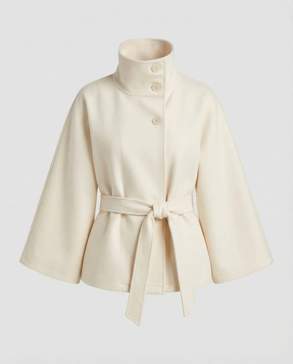 Cream belted cape jacket laid flat, highlighting the tall stand collar and self-tie waist belt
