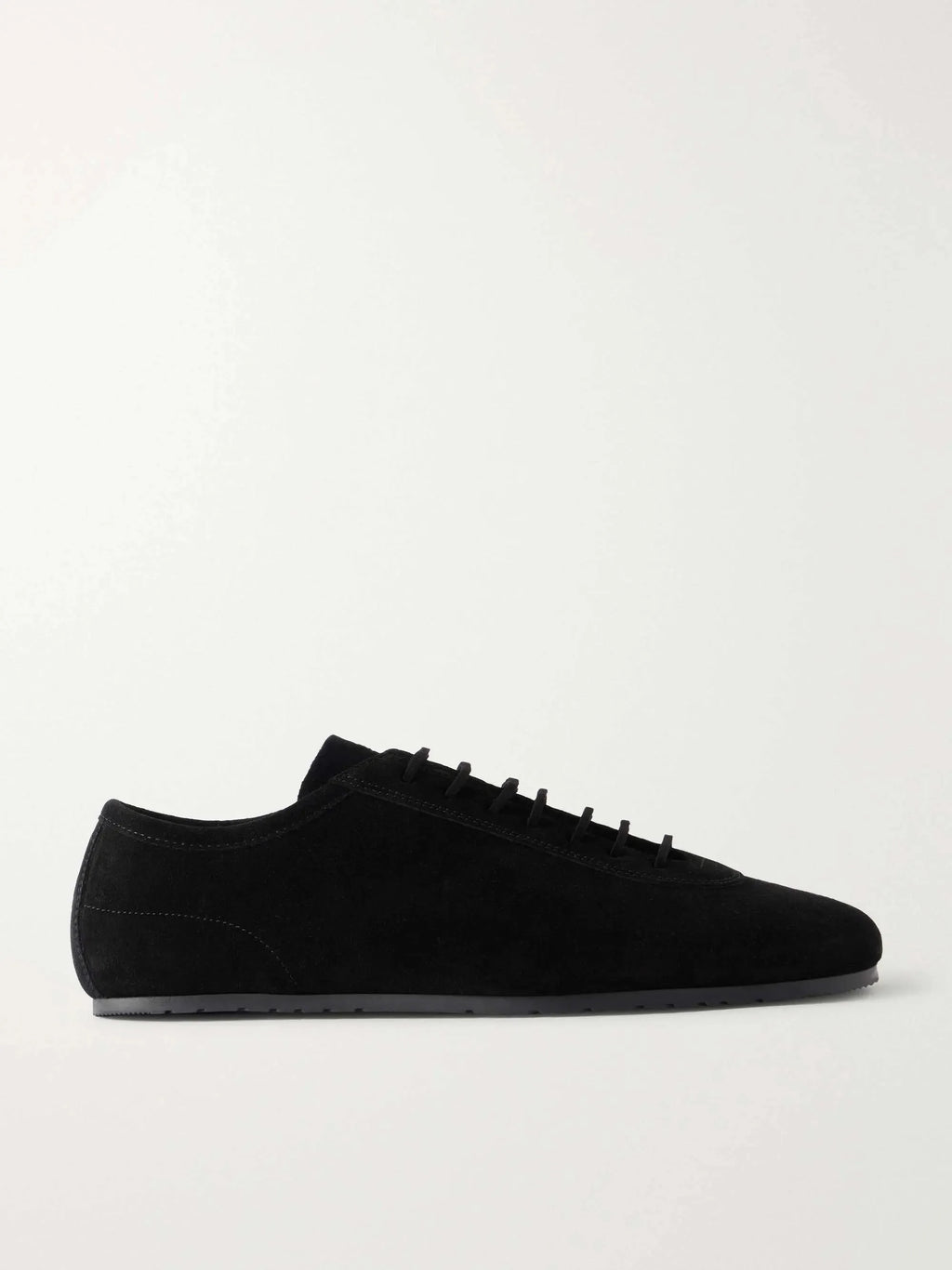 Side profile of a black suede lace-up sneaker with a rounded toe and thin flat sole on a plain background.