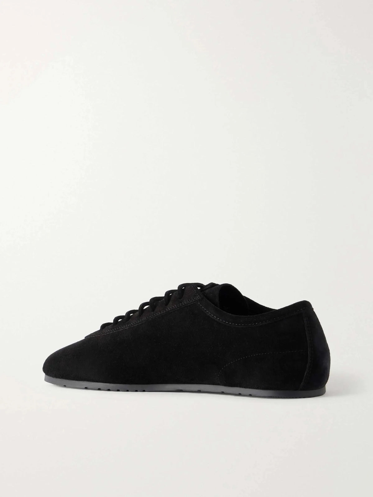 Back and side angle of a black suede sneaker highlighting the low-cut heel collar and sleek silhouette.