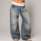 Front view of light blue baggy wide-leg denim jeans with a cream ribbed waistband and curved seam detailing