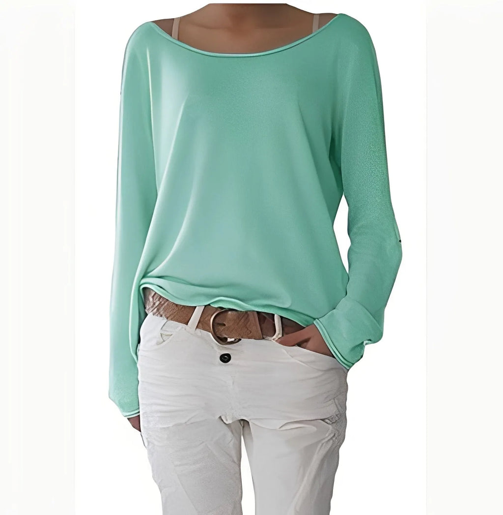 Mint green boat neck jumper with soft flowing fabric and long cuffed sleeves, worn with white trousers