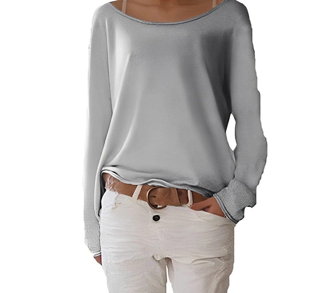 Light grey boat neck jumper with relaxed silhouette and folded cuffs, styled over white trousers with a tan belt