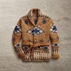 Brown knitted shawl-collar cardigan with navy and cream Aztec jacquard pattern, belted waist and popper buttons, laid flat.