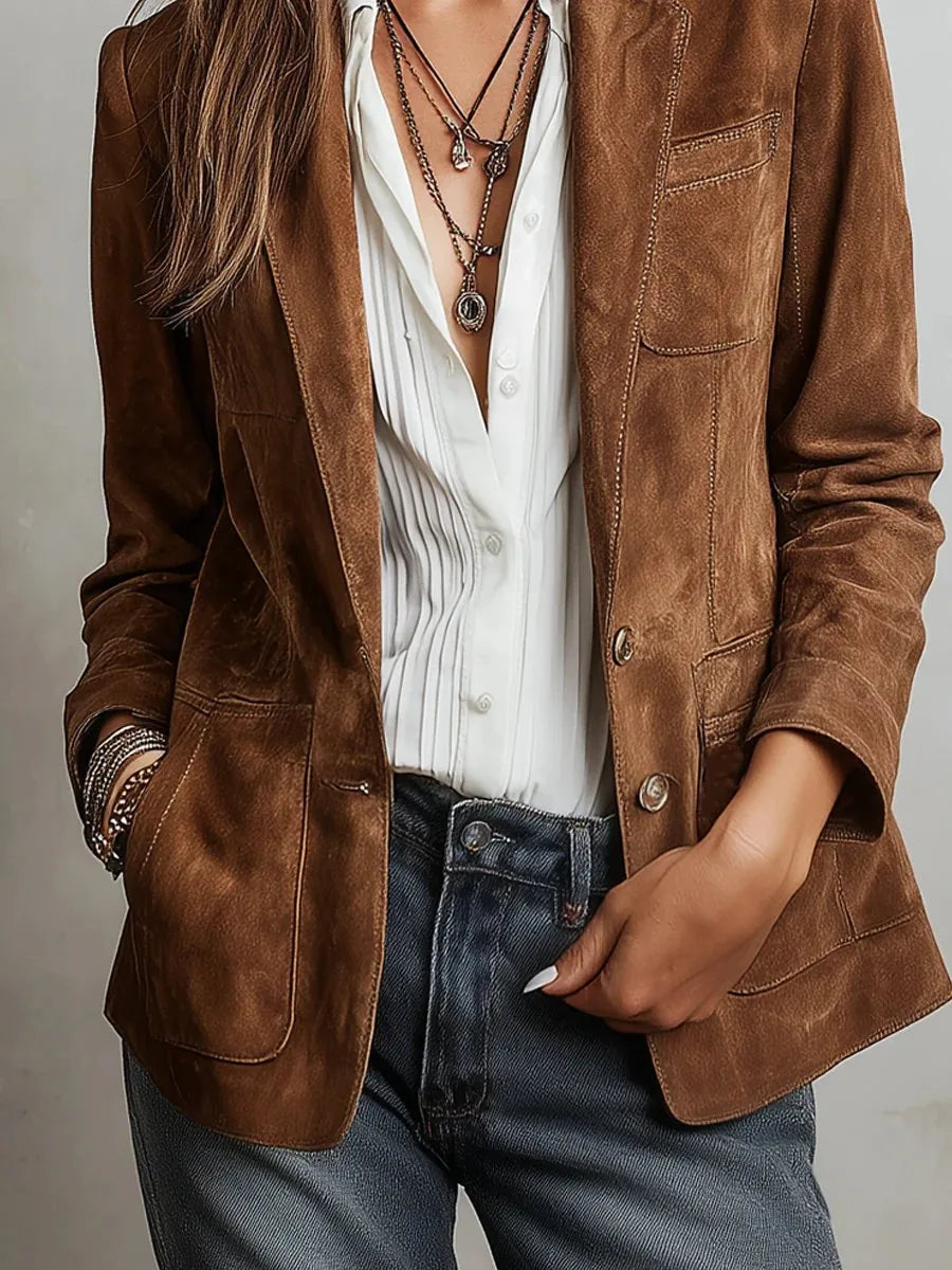Front-facing close-up showing the button fastening and lower patch pockets of the suede jacket