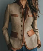 Side-angled view showing the tweed blazer's leather-trimmed chest and hip pockets, contrast piping and antique-style buttons.