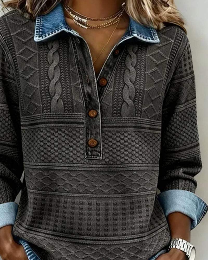Front view of grey cable knit jumper showing button placket and denim-trimmed collar with jewellery