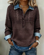Brown cable knit jumper with blue denim collar and cuffs, hands in jean pockets