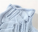 Close-up of the light blue polo neck collar showing ribbed trim and intricate cable and openwork stitching