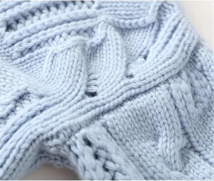 Detailed view of the cable-knit texture in light blue, highlighting raised braids and small openwork holes