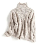 Beige cable-knit polo neck jumper laid flat, showing the same textured leaf and cable stitch pattern