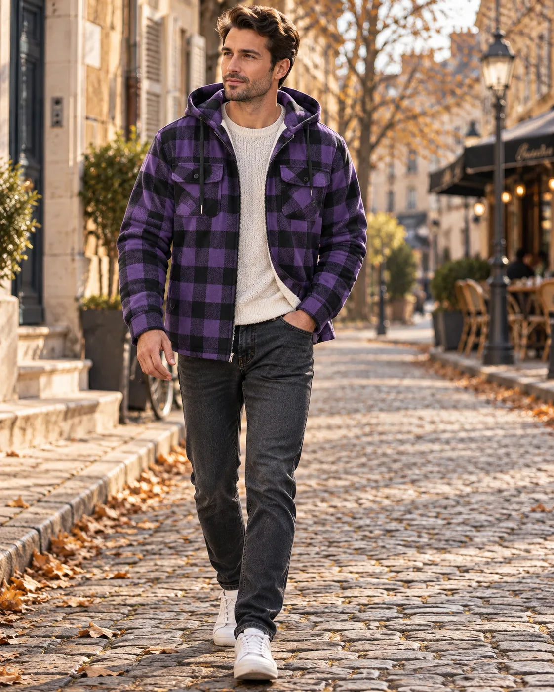 Man wearing a purple and black checked hooded jacket with sherpa lining, zipped open over a cream jumper and grey jeans