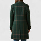 Back view of the green checked coat showing its tailored fit and back seam detailing