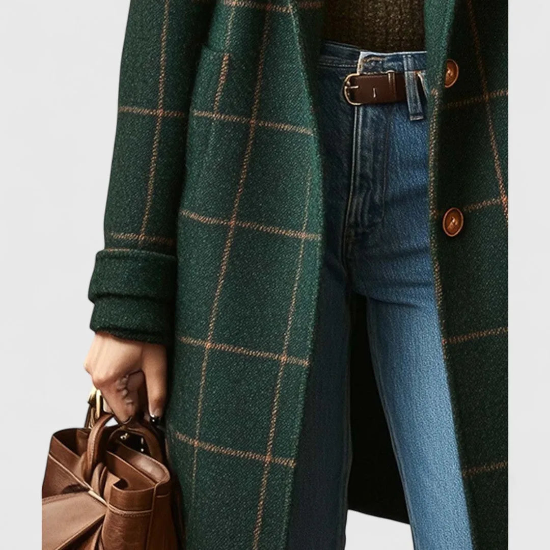 Detail of the coat sleeve cuff and buttoned front against denim trousers