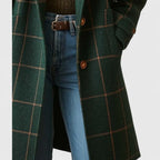 Close-up of tan buttons and checked wool fabric texture on the coat's front closure