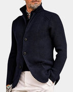 Close-up side angle of navy blue ribbed knit cardigan showing stand collar, button placket and raglan sleeve seam