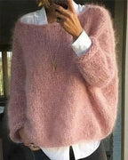 Close-up front view of a dusty pink chunky knit jumper with wide sleeves, worn open over a white shirt
