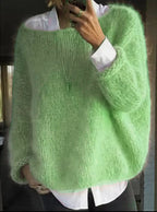 Soft mint green fluffy knit jumper worn open over a white shirt, close-up front detail view
