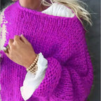 Detail shot of a magenta pink chunky hand-knit jumper with ribbed cuff and wooden bead bracelet