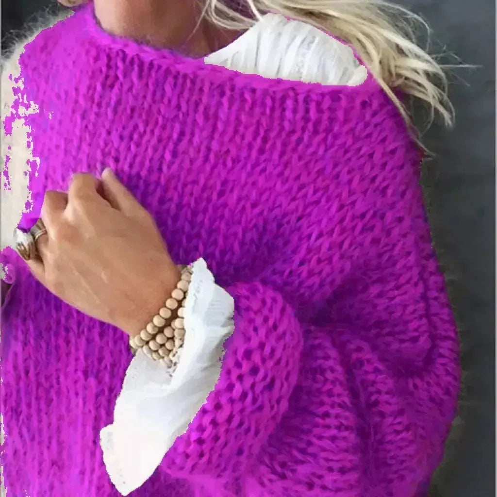 Detail shot of a magenta pink chunky hand-knit jumper with ribbed cuff and wooden bead bracelet