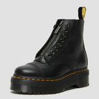 Angled studio shot of a single black pebbled leather boot showing the front zip, round toe and ridged platform sole