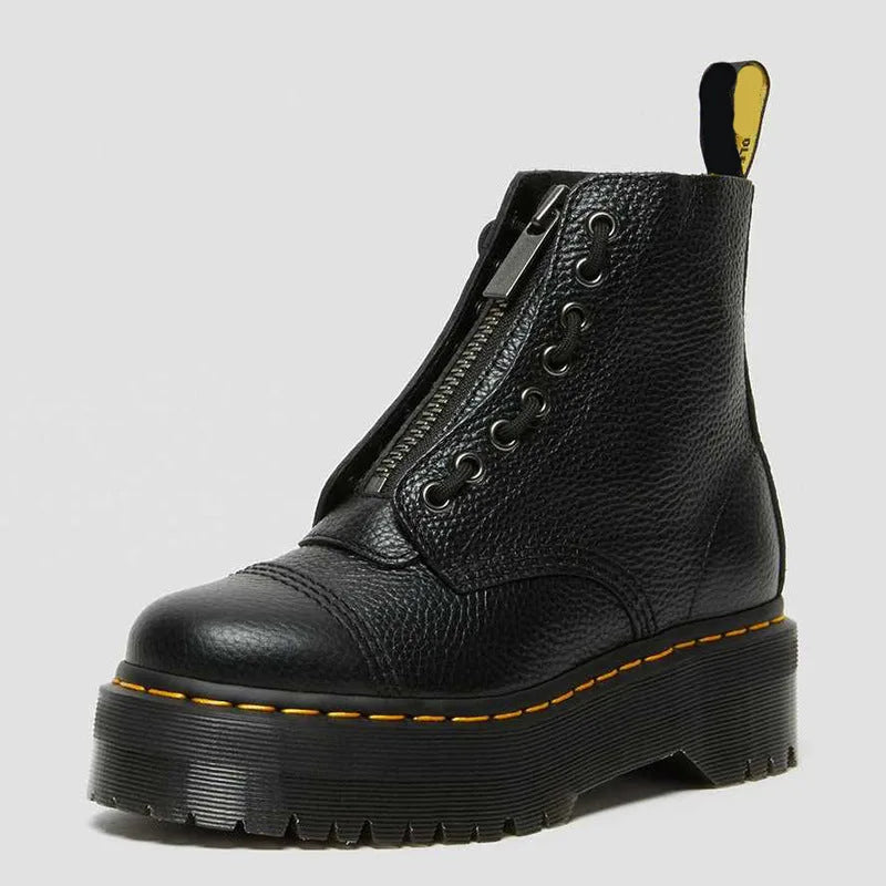 Angled studio shot of a single black pebbled leather boot showing the front zip, round toe and ridged platform sole