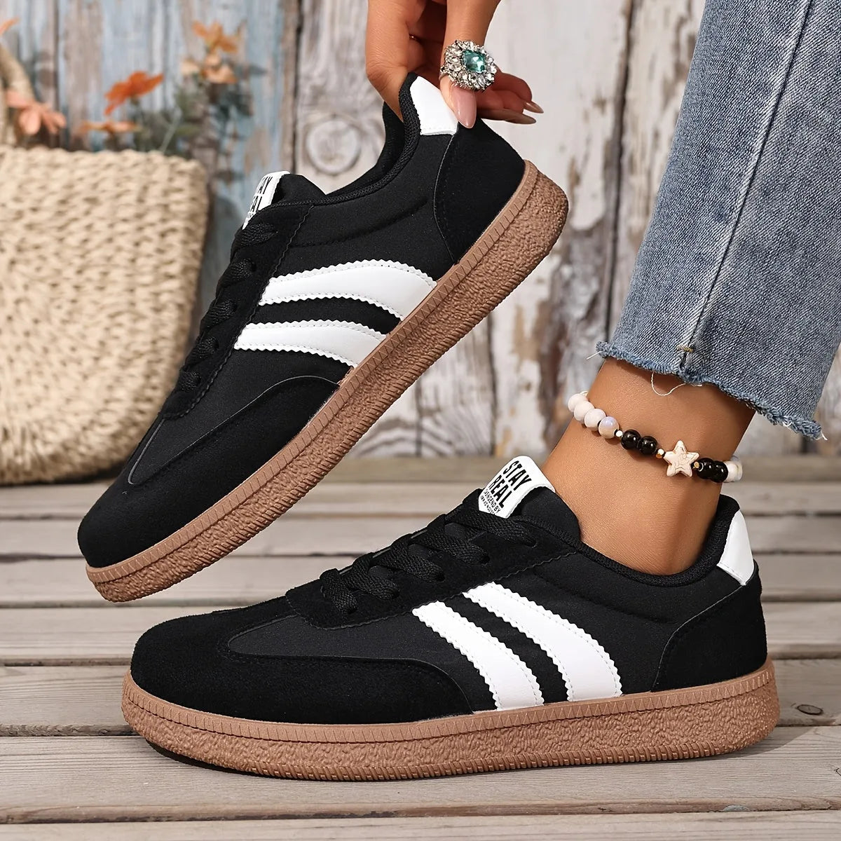 Pair of white trainers with black stripes resting on beige carpet flooring