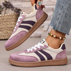 Side view of navy trainer showing white stripes, lace-up front and gum sole