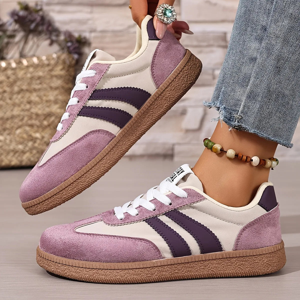 Side view of navy trainer showing white stripes, lace-up front and gum sole