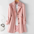 Close-up view of the pink trench coat highlighting the notch collar, button front and tailored waist seam