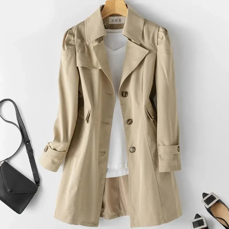 Khaki trench coat with a checked inner collar detail, shown open over a white top with a crossbody bag nearby