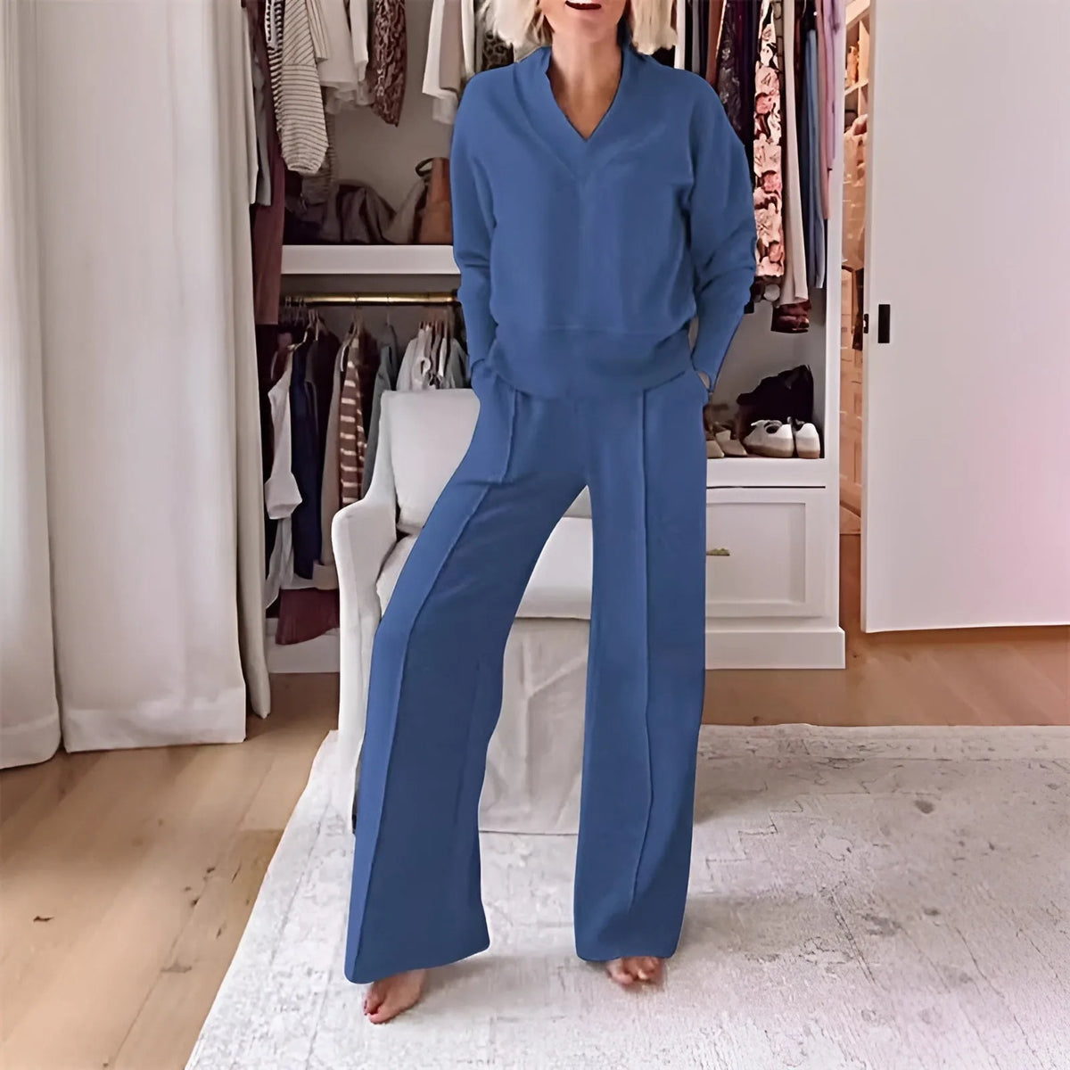 Front view of a woman wearing the set in denim blue, v-neck jumper and wide-leg trousers