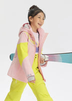 Girl in a pink and yellow colour-block ski jacket carrying skis under her arm while walking