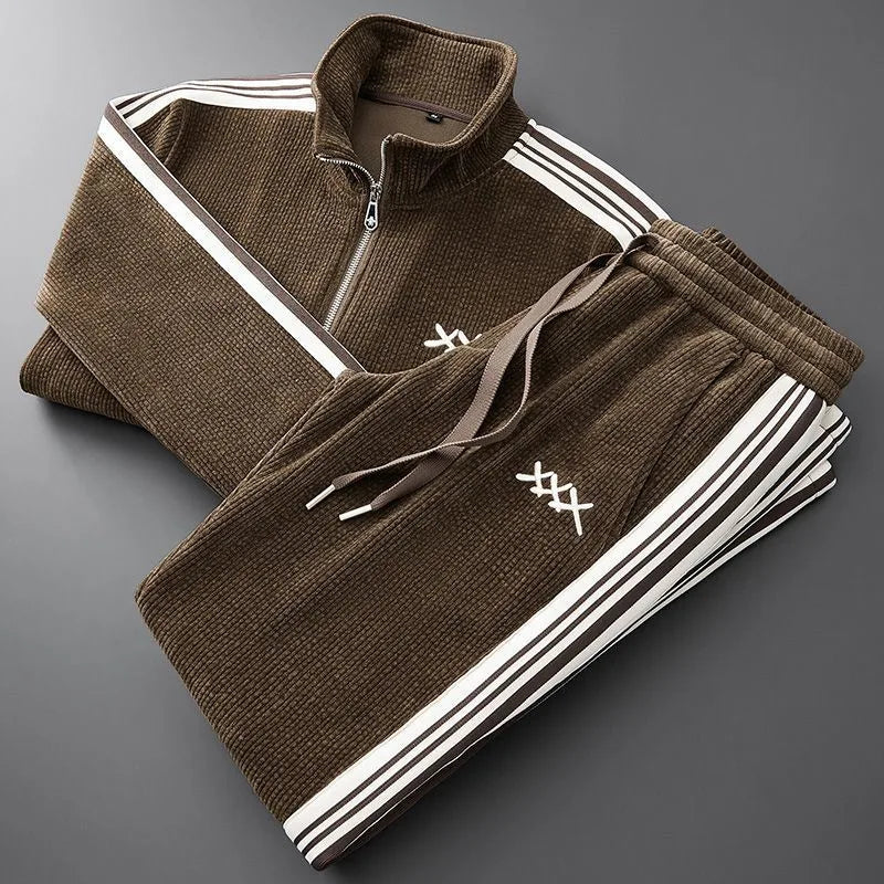 Folded brown corduroy tracksuit set showing ribbed texture, stand collar zip jacket and drawstring joggers with side stripes