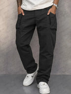 Model wearing black cotton cargo trousers with zippered side pockets and straight leg silhouette