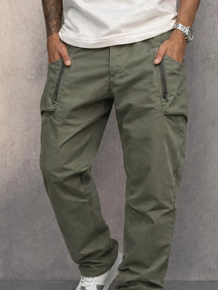 Close-up of army green cargo trousers highlighting zip pocket stitching and fabric texture