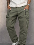 Close-up of army green cargo trousers highlighting zip pocket stitching and fabric texture
