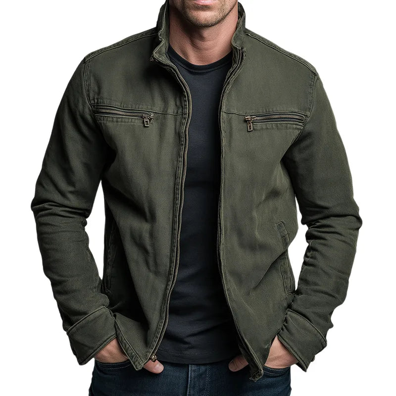 Front view of man wearing an olive green cotton zip jacket with twin chest zip pockets, worn over a navy t-shirt