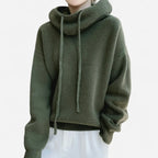 Detail shot of green cowl neck hooded jumper showing ribbed cuffs and textured knit fabric