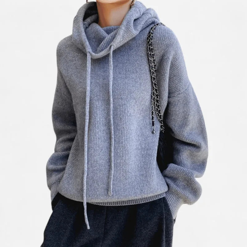 Grey marl cowl neck knit hoodie worn with a chain-strap handbag and dark trousers