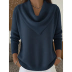 Front view of the jumper in navy blue, showing the cowl neckline and ribbed cuffs on a model