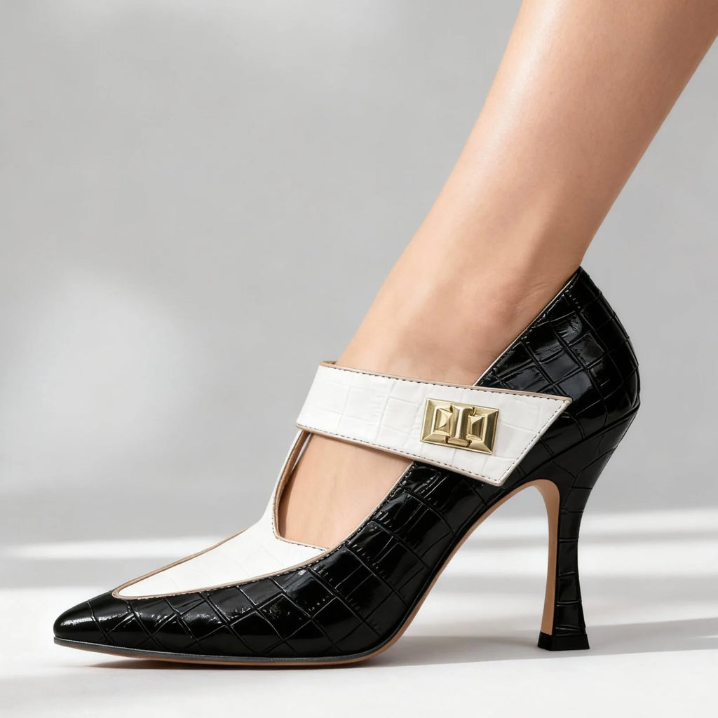 Studio shot of black croc-print stiletto with cream T-strap and gold buckle against a plain grey background