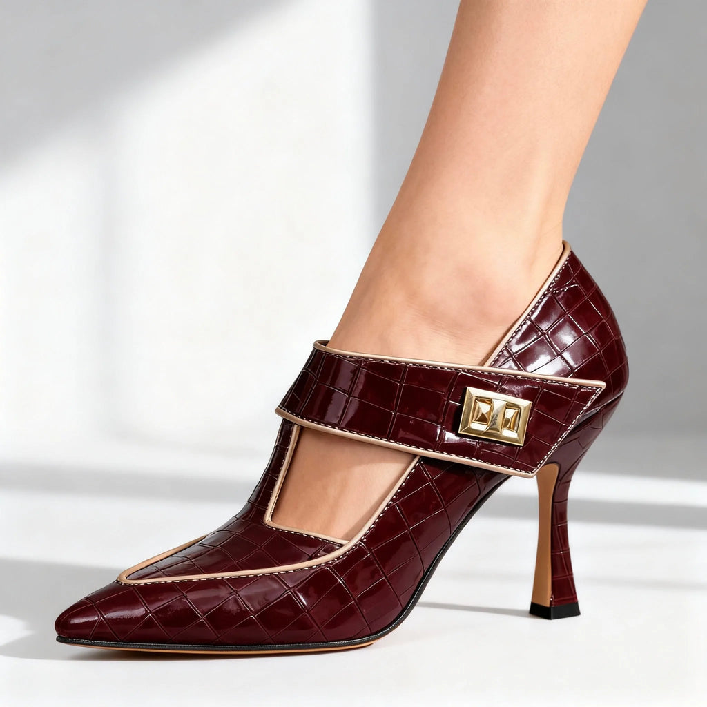 Studio side view of burgundy croc-embossed pump with beige trim and gold buckle on a plain background