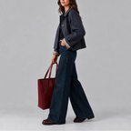 Side profile of the navy cropped jacket in motion, showing the checked cuff and boxy cropped fit