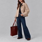 Side angle of the beige cropped jacket paired with denim, showing the relaxed cropped silhouette