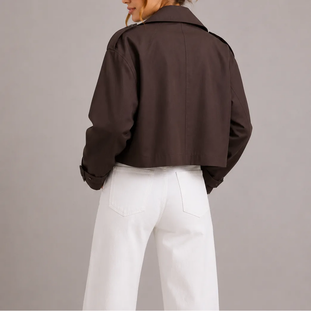 Back view of the dark brown cropped trench jacket showing its boxy fit and back seam detailing
