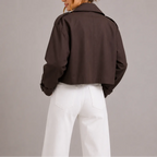 Back view of the dark brown cropped trench jacket showing its boxy fit and back seam detailing