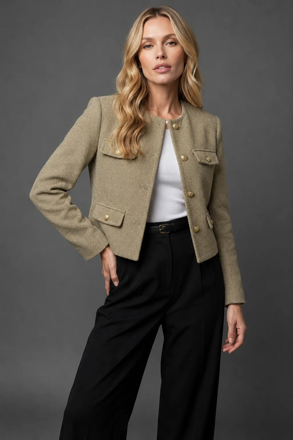 Close-up of a flap pocket with gold button on the cream tweed jacket showing the woven texture