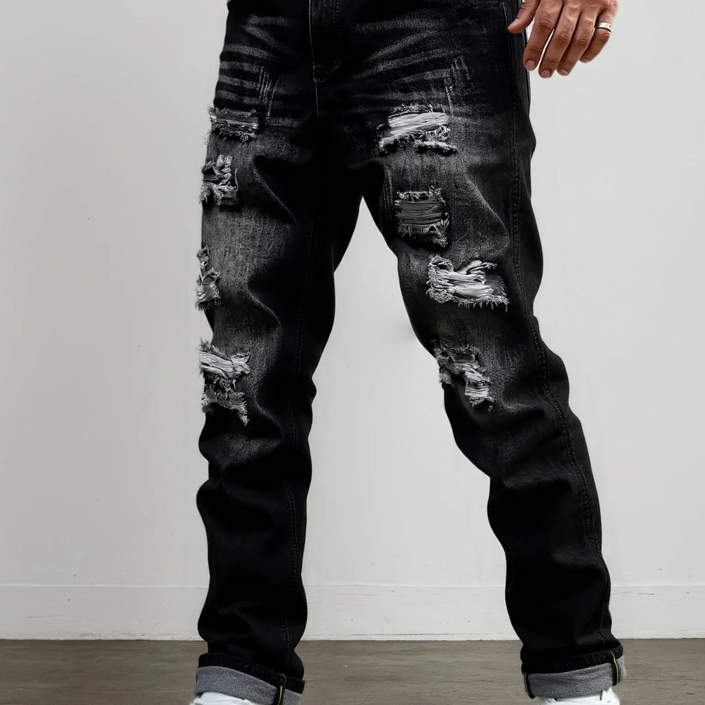 Front view of dark grey ripped straight-leg jeans styled with a turned-up hem and white trainers