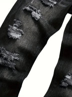 Close-up of the inner leg seam and multiple distressed rip patches on dark grey denim